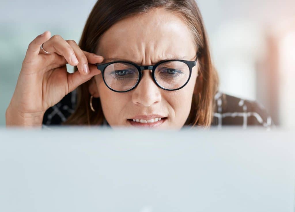 Mujer con gafas mirando una pantalla de cerca