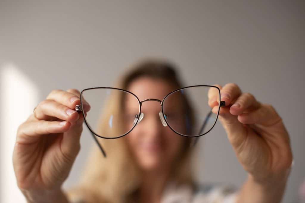 Mujer sujetando unas gafas frente a ella