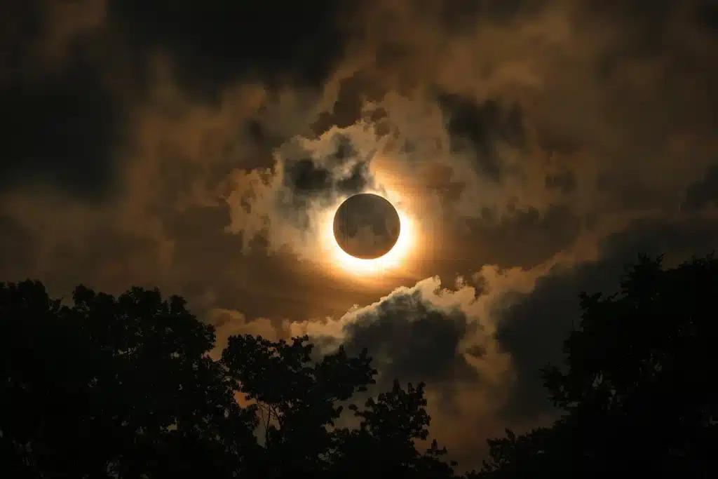 Eclipse solar parcialmente cubierto entre nubes oscuras